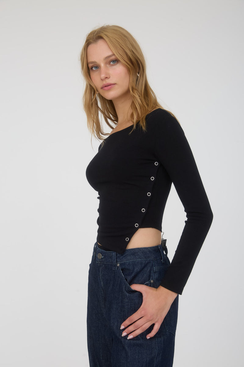 Fitted black long sleeve crop top featuring asymmetrical snap button detail for a trendy look, perfect for Long Island boutique fashion.