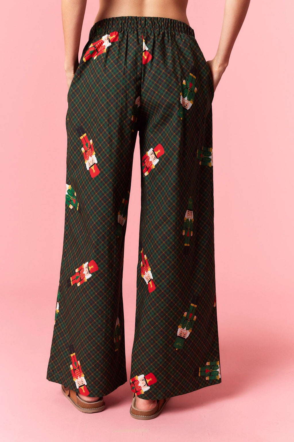 Model wearing Holiday Toy Soldier Cotton Poplin Pajama Pants in hunter green with red bow tie — festive nutcracker print sleepwear available at TandyWear Boutique in Commack, NY. front view