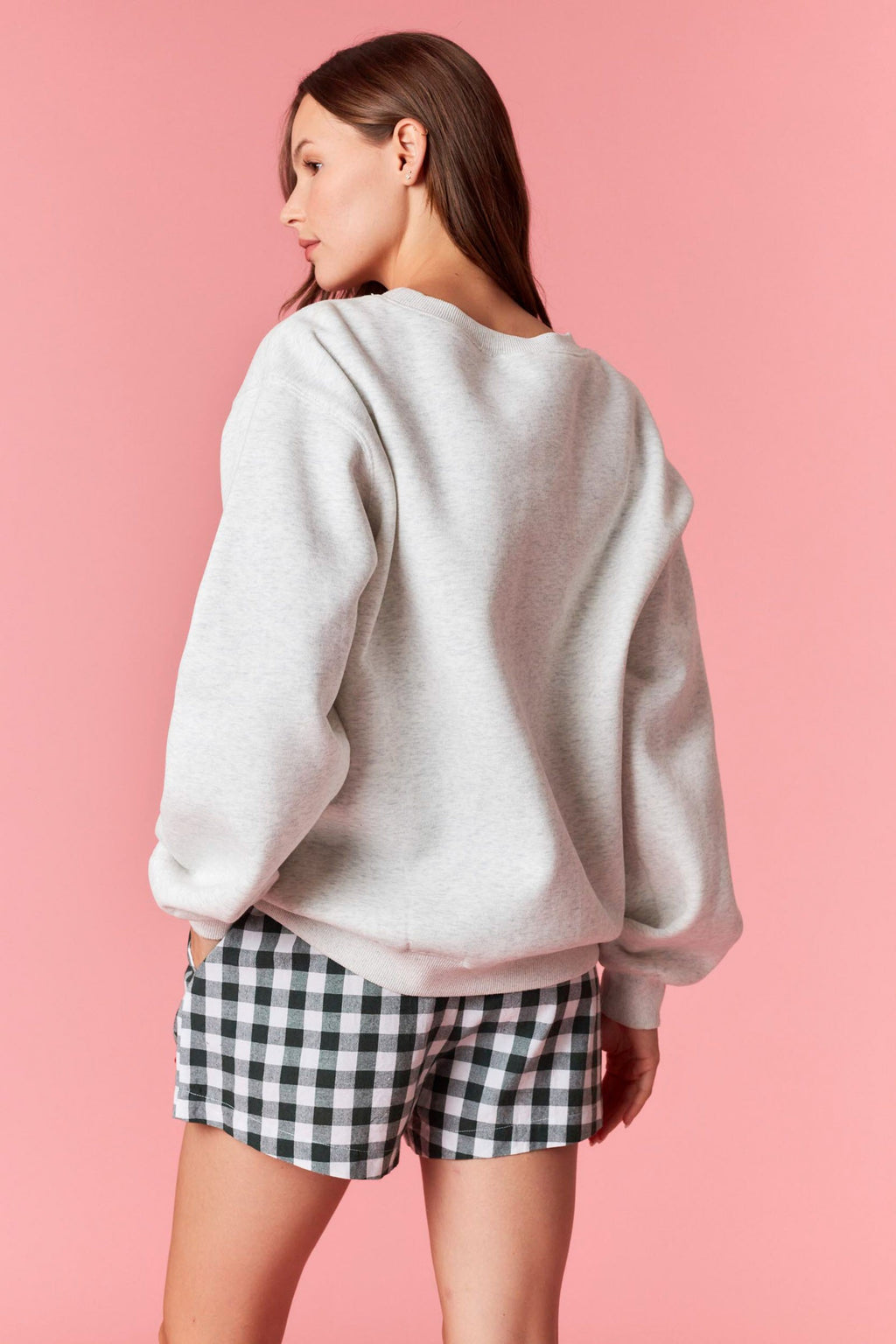 Model wearing “Merry Everything” embroidered fleece sweatshirt in heather grey — cozy pullover with stacked gift embroidery, available at TandyWear Boutique in Commack, NY. front view