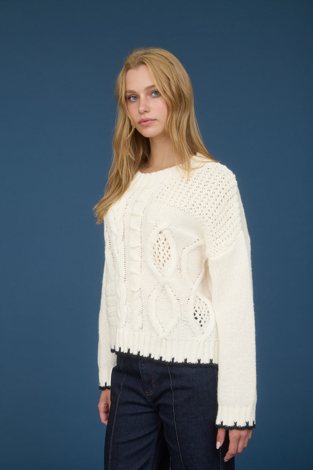 Cozy cream cable knit sweater featuring intricate detailing and a scalloped hem, perfect for Long Island boutique fashion.