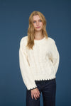 Cozy cream cable knit sweater featuring intricate detailing and a scalloped hem, perfect for Long Island boutique fashion.