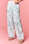 Model wearing Holiday Scenery Print Fleece Terry Sweatpants in dusty blue — relaxed-fit lounge pants with winter village print, available at TandyWear Boutique in Commack, NY. front view