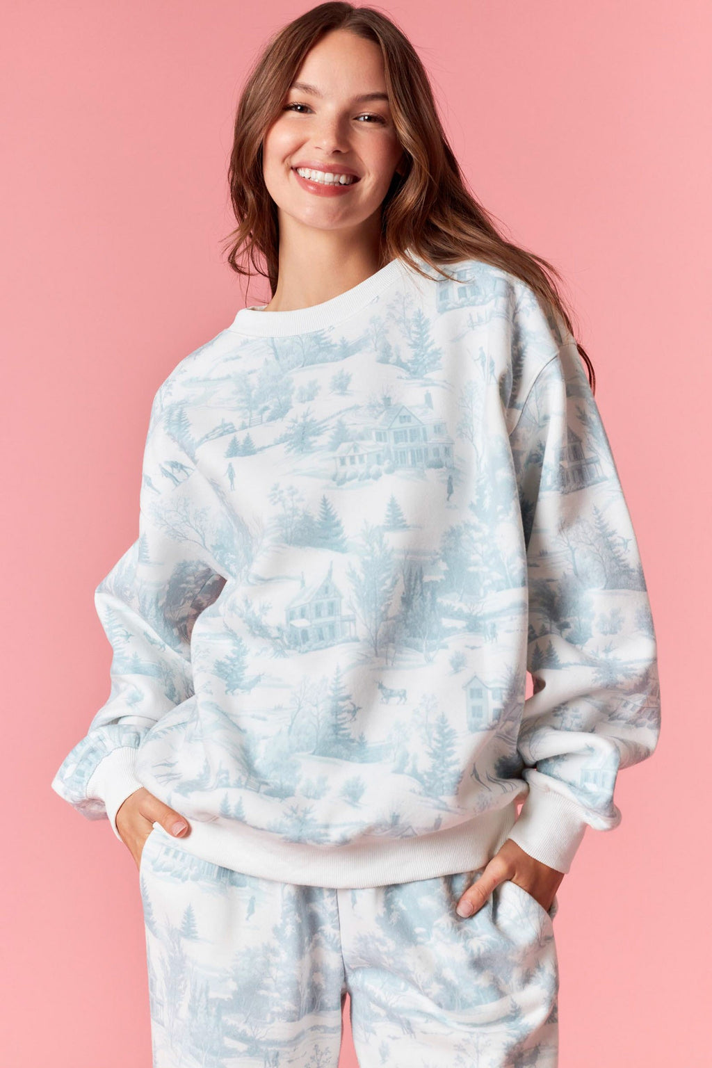 Model wearing Holiday Scenery Print Fleece Terry Sweatshirt in dusty blue — soft pullover with winter village print, available at TandyWear Boutique in Commack, NY. front view