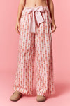 Model wearing Holiday Toy Soldier Cotton Poplin Pajama Pants in baby pink and ivory — wide-leg style with oversized bow waist, available at TandyWear Boutique in Commack, NY.