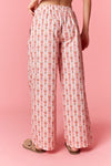 Model wearing Holiday Toy Soldier Cotton Poplin Pajama Pants in baby pink and ivory — wide-leg style with oversized bow waist, available at TandyWear Boutique in Commack, NY. back view 