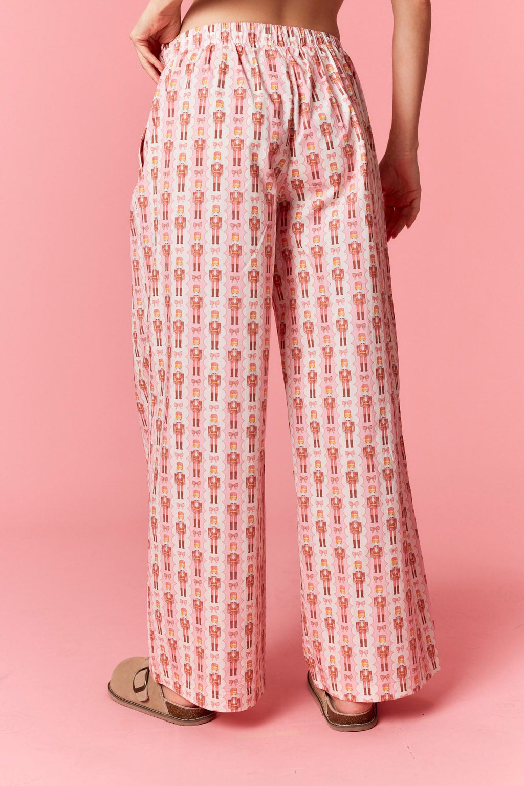 Model wearing Holiday Toy Soldier Cotton Poplin Pajama Pants in baby pink and ivory — wide-leg style with oversized bow waist, available at TandyWear Boutique in Commack, NY.
