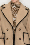 Double breasted beige jacket with black blanket stitch detailing and large buttons, perfect for stylish layering in Long Island boutique fashion.
