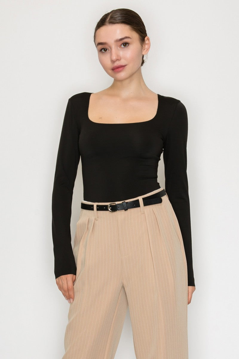 Women’s black square neck long sleeve bodysuit — fitted stretch knit with snap closure, sleek minimalist top available at TandyWear Off Price, Commack NY. front view with bottoms