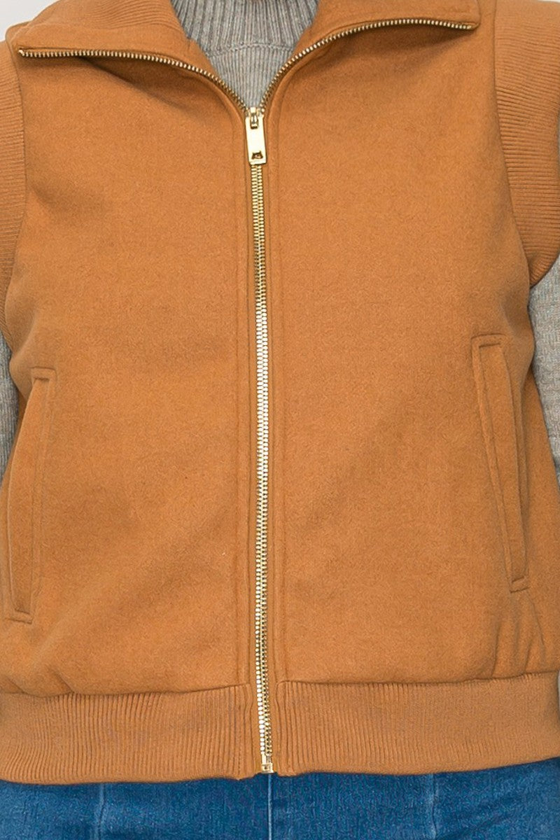 Cozy front zip knitted vest in warm rust color, featuring two side pockets and ribbed hem, perfect for Long Island boutique fashion.