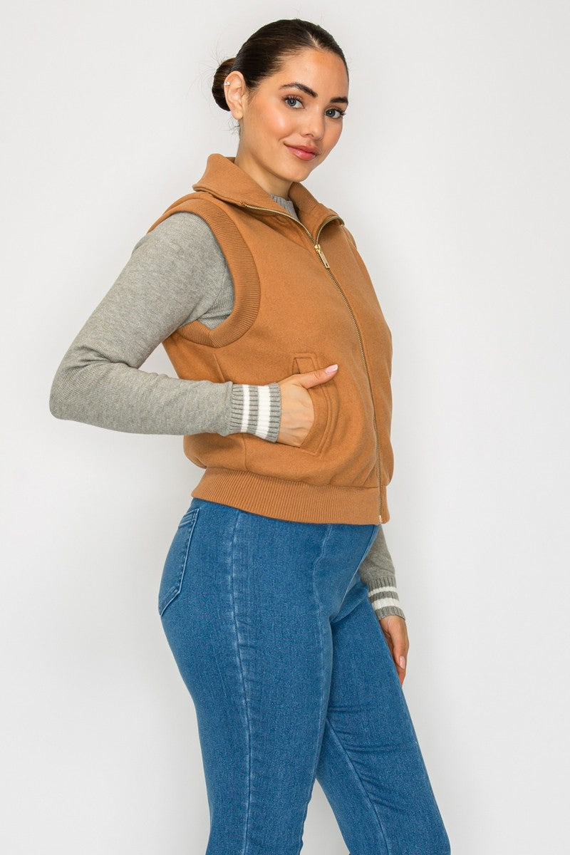 Front zip knitted vest in warm tan hue, featuring side pockets and a modern fit, perfect for layering in Long Island boutique fashion.