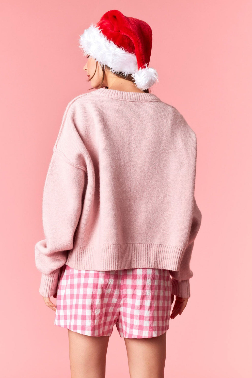 Model wearing pink Santa knited Sweater featuring vintage Santa design — cozy knit pullover available at TandyWear Boutique in Commack, NY. front view