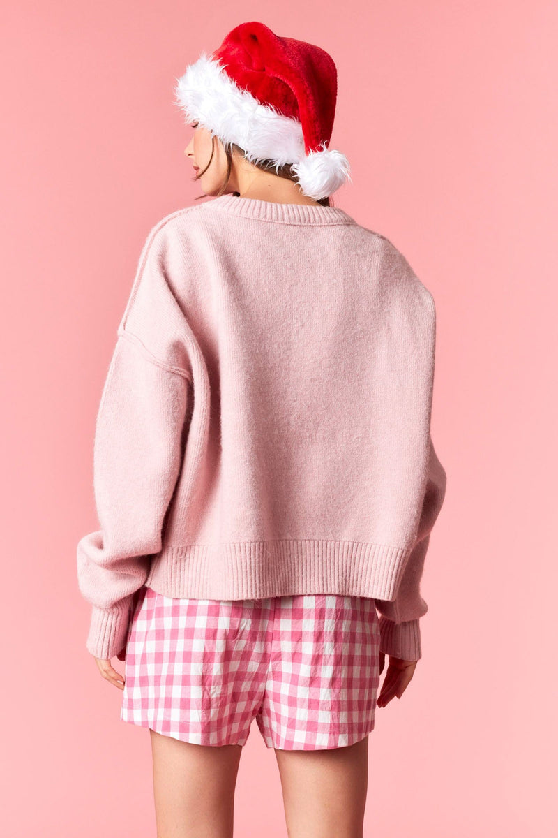 Model wearing pink Santa Embroidered Sweater featuring vintage Santa design — cozy knit pullover available at TandyWear Boutique in Commack, NY.