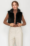 Model wearing black faux fur cropped vest jacket with zip-front closure