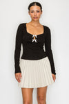 Black rhinestone bow knit top with square neckline and long sleeves – available at Off Price TandyWear