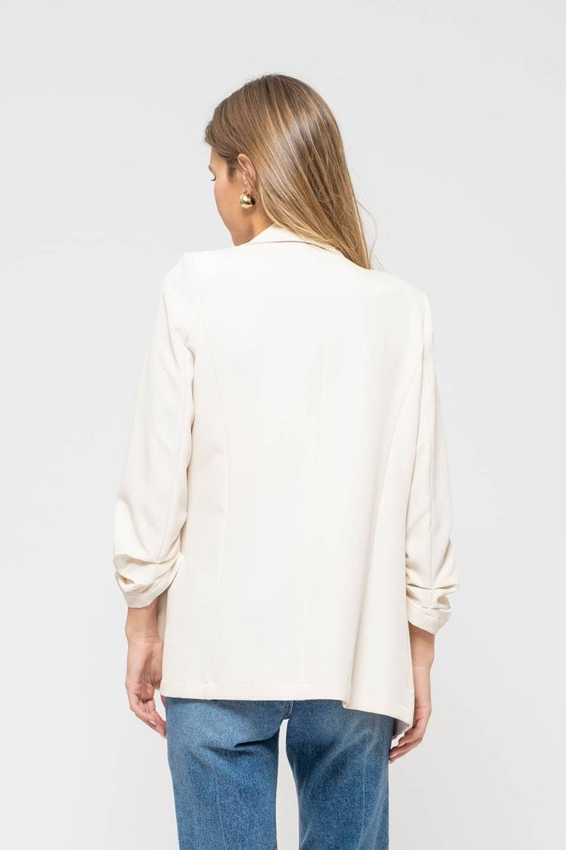Elegant cream 3/4 ruched sleeve blazer with a tailored fit, perfect for adding a touch of sophistication to your Long Island boutique fashion wardrobe.