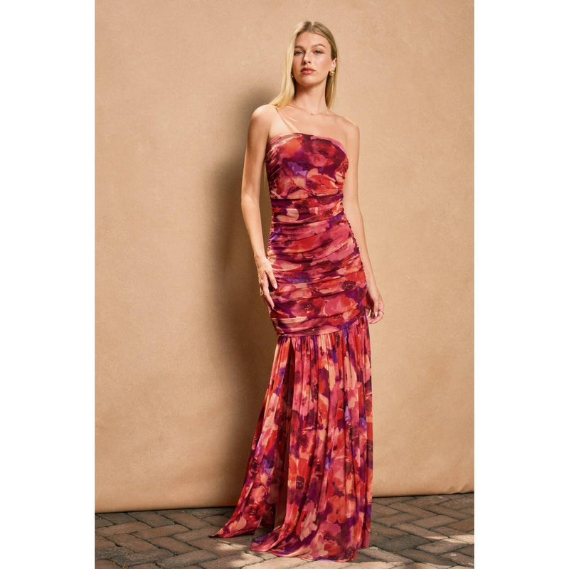 Striking ruched tube top dress in rich shades of red and purple, flowing from a fitted bodice to a dramatic skirt, ideal for Long Island boutique fashion.