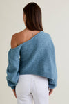 Soft blue asymmetrical shoulder sweater top with a cropped fit and oversized sleeves, perfect for Long Island boutique fashion.