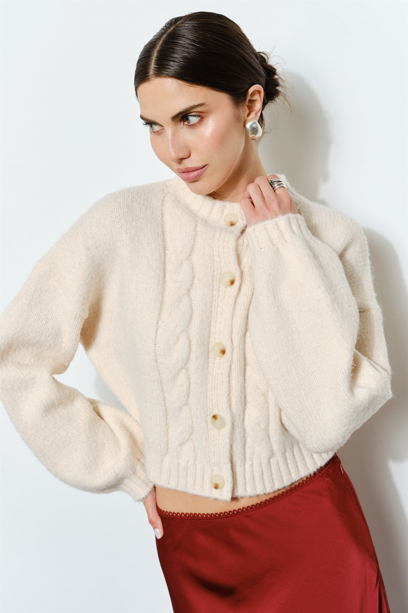 Cozy cream cable knit cardigan with a cropped fit and button closure, perfect for layering in Long Island boutique fashion.