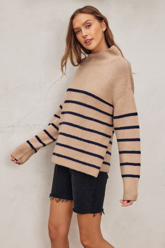 Oversized beige sweater with a high neck and navy stripes, perfect for cozy layering in Long Island boutique fashion.