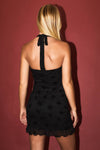Black halter neck mini dress with a fitted silhouette, delicate floral pattern, and ruffled hem, ideal for Long Island boutique fashion.