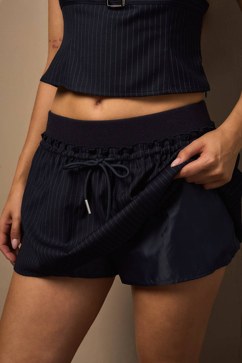 Navy bandeau top with front belt detail paired with a matching mini skort, perfect for a chic look from a Long Island boutique fashion.