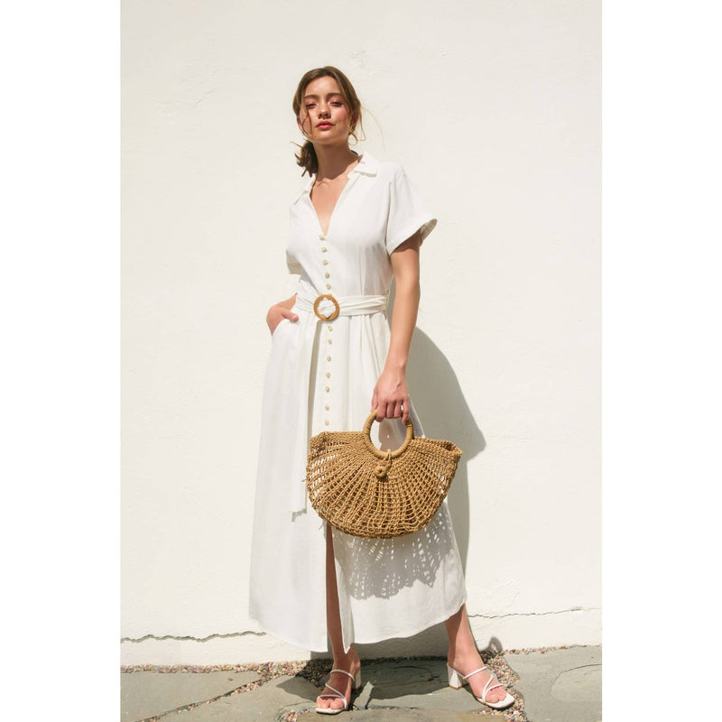 Elegant white maxi dress with short sleeves, button details, and a wicker belt, paired with a woven handbag for a fresh Long Island boutique fashion look.