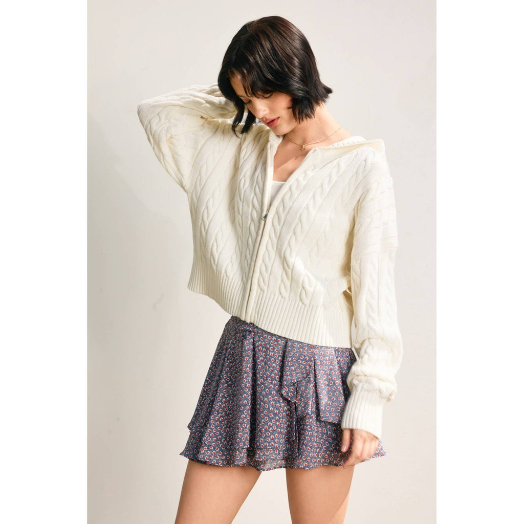 Cozy cream cable knit hooded zip-up cardigan pairs beautifully with a floral skirt for effortless Long Island boutique fashion.