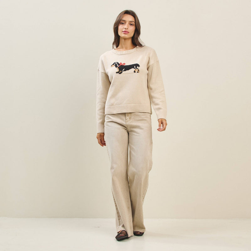 Cream-colored sweater featuring a playful bow dog graphic on the front, perfect for cozy days in Long Island boutique fashion.