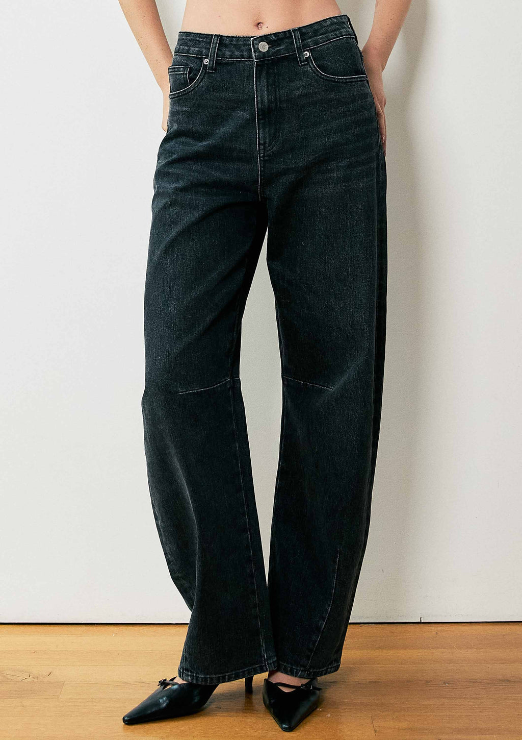 High-waisted barrel baggy jeans in a sleek black wash feature a relaxed fit and subtle stitching, perfect for Long Island boutique fashion.