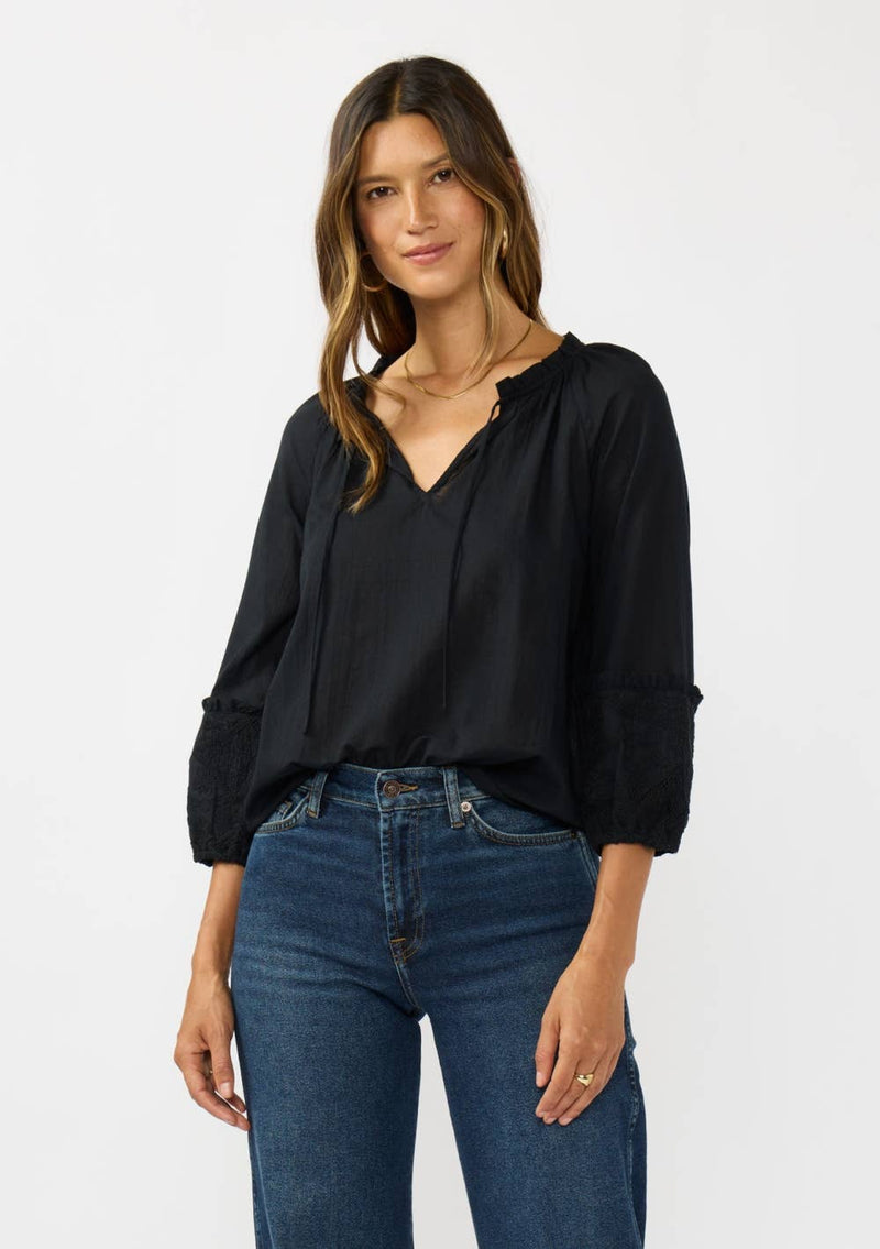 Chic black frilled sleeve split neck blouse featuring delicate lace details, perfect for stylish ensembles at a Long Island boutique fashion.
