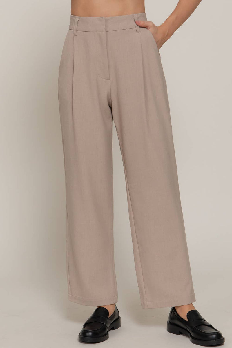 Chic beige front pleats detail pants with a relaxed fit, perfect for sophisticated looks at this Long Island boutique fashion spot.