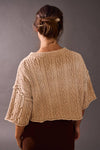 Chunky cable-knit sweater top in a soft beige hue, featuring an acid wash detail and a cropped fit, perfect for Long Island boutique fashion.