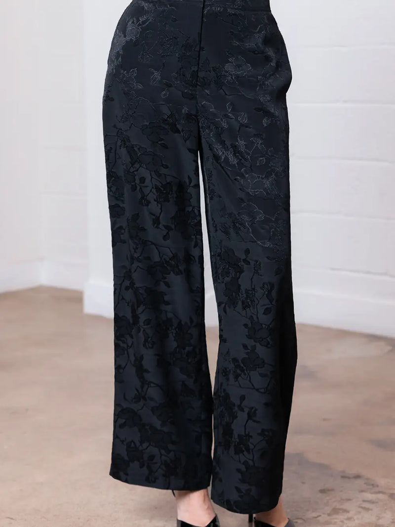 Elegant floral straight leg pants in dark fabric featuring subtle floral patterns, perfect for a chic look at this Long Island boutique fashion.