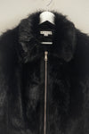Luxurious black faux fur zippered jacket with a plush texture and a stylish stand-up collar, perfect for Long Island boutique fashion.