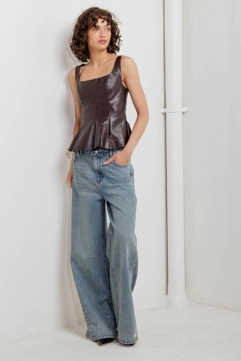 Sophisticated brown faux leather top with a square neckline and flared hem, paired with relaxed light blue jeans, perfect for Long Island boutique fashion.