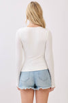 Fitted double layer V-neck long sleeve top in white, perfect for layering, paired with denim shorts for a chic Long Island boutique fashion look.