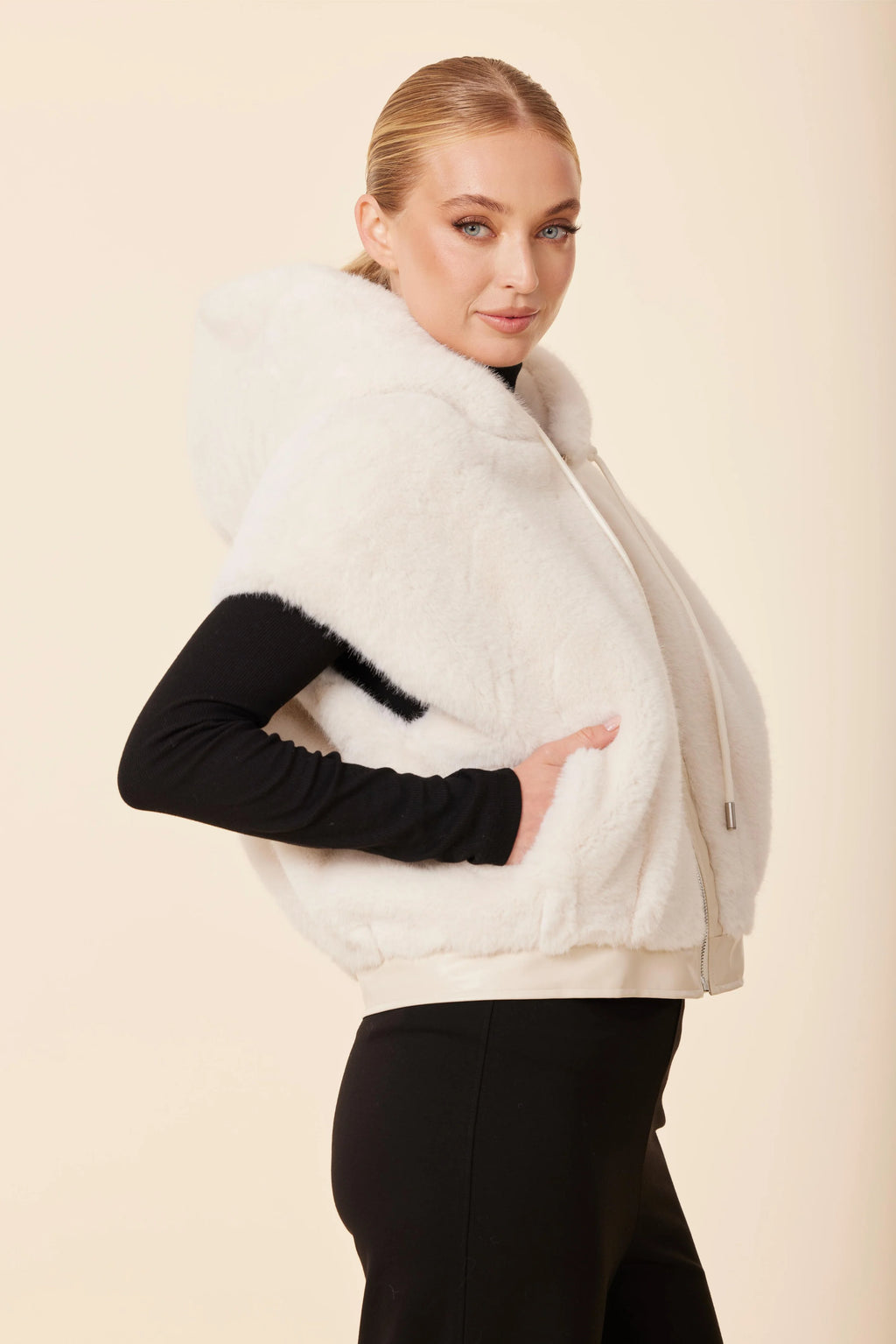 Stylish white faux fur vest with a luxurious vegan leather trim, featuring a cozy hood and zip closure, perfect for Long Island boutique fashion.