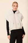 Stylish white faux fur vest with a luxurious vegan leather trim, featuring a cozy hood and zip closure, perfect for Long Island boutique fashion.