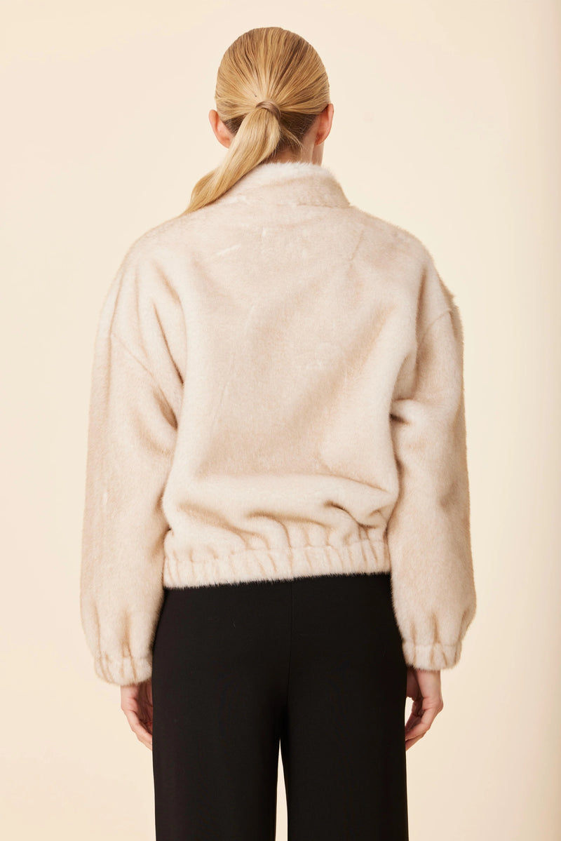 Stylish Dolce Cabo faux mink fur jacket in soft beige with a relaxed fit and elastic hem, perfect for Long Island boutique fashion.