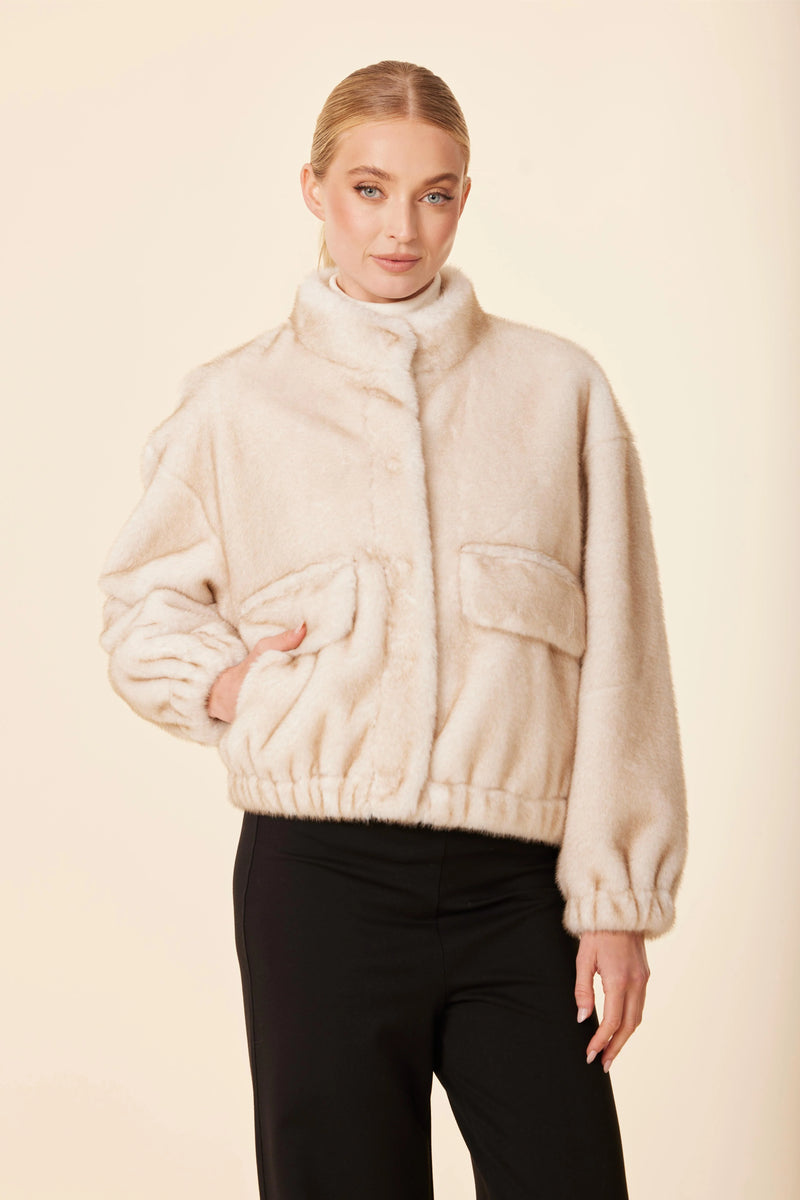 Cozy beige faux mink fur jacket with a high collar, elastic hem, and front pockets, perfect for Long Island boutique fashion during colder months.