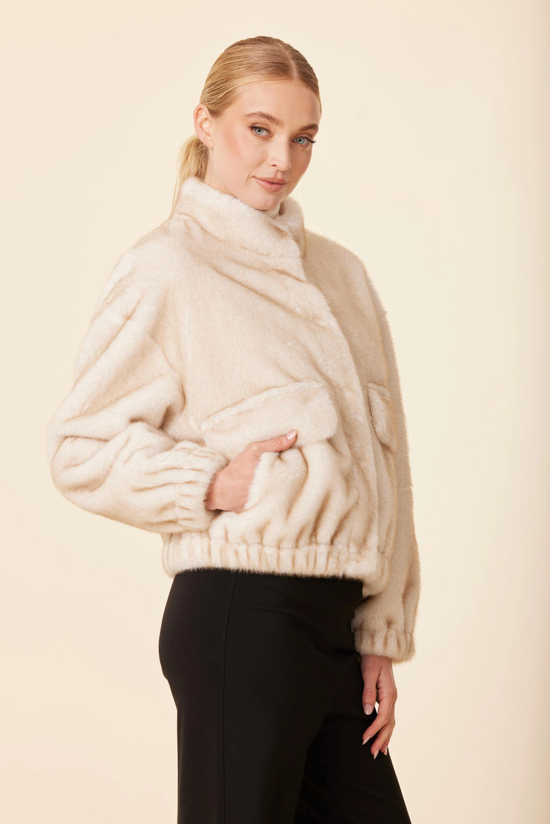 Soft, cream-colored faux mink fur jacket with a relaxed fit, playful cropped hem, and side pockets, perfect for Long Island boutique fashion.