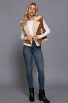 Faux suede zip-up vest with plush inner fur lining in taupe, styled over a white top and paired with skinny jeans, perfect for Long Island boutique fashion.