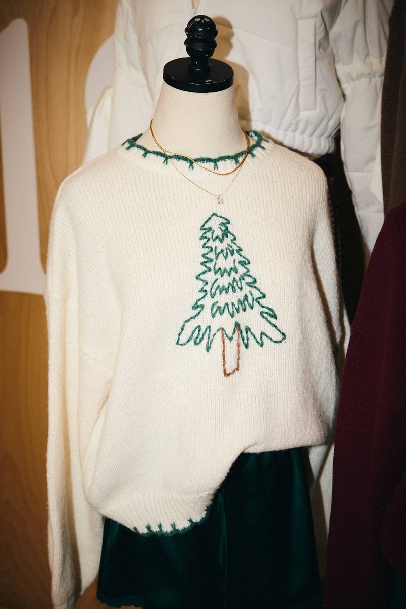 Cozy oversized sweater in cream featuring green and brown "Christmas Tree" stitching, perfect for festive Long Island boutique fashion.