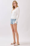 Fitted white double layer V-neck long sleeve top paired with denim shorts for a casual look, perfect for Long Island boutique fashion.