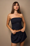 Bandeau top in navy pinstripe with front belt detail, paired with a matching mini skort, perfect for stylish Long Island boutique fashion.