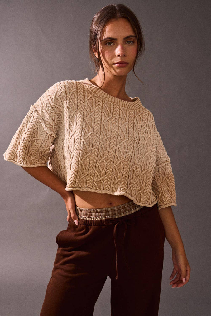 Cropped beige sweater top featuring a textured cable knit design and wide sleeves, ideal for Long Island boutique fashion enthusiasts.