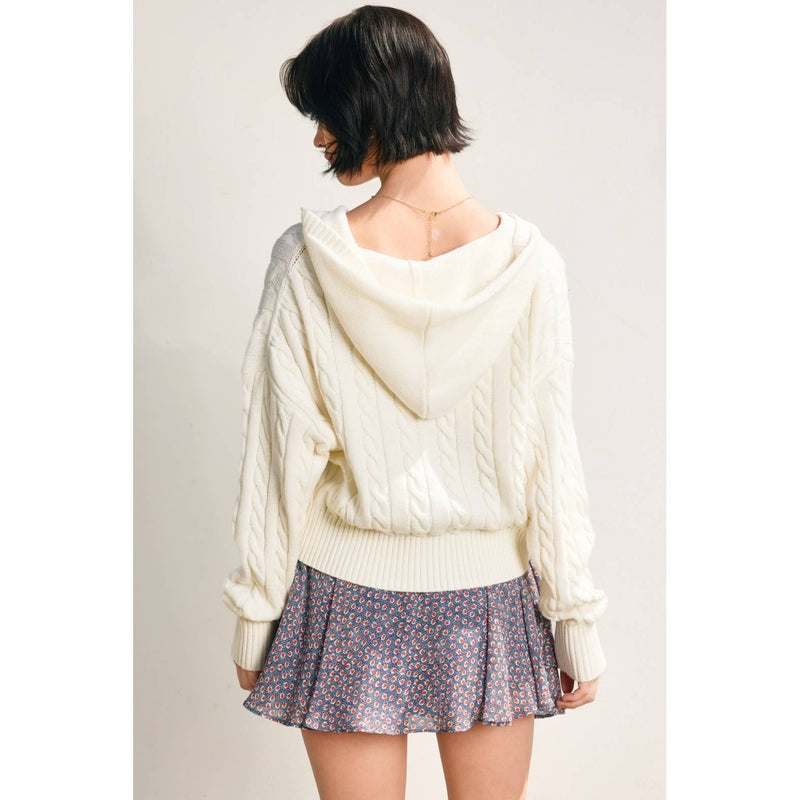 Cozy cable knit hooded zip-up cardigan in ivory, featuring a relaxed fit and ribbed cuffs, perfect for Long Island boutique fashion.