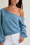 Asymmetrical shoulder sweater top in soft blue, featuring a relaxed fit and oversized sleeves, perfect for Long Island boutique fashion.