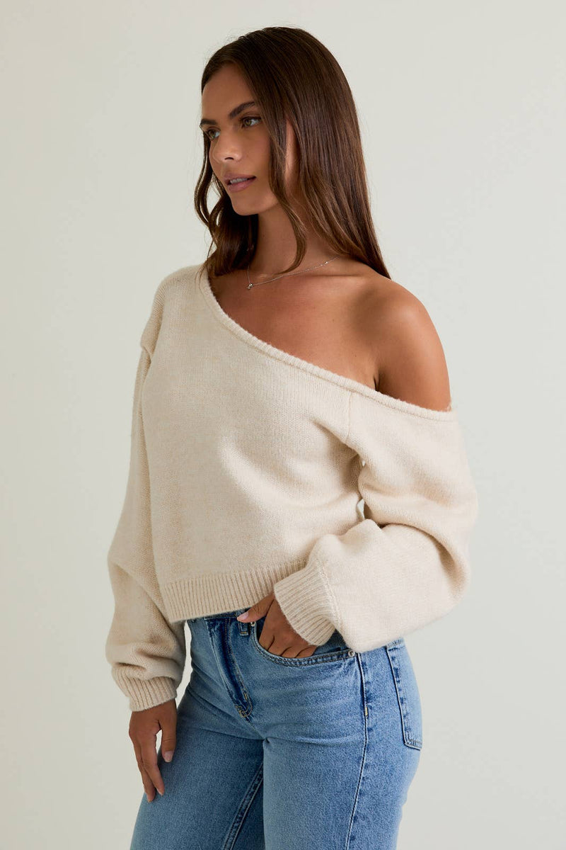 Cozy asymmetrical shoulder sweater top in soft cream, featuring a relaxed fit and ribbed detailing, perfect for Long Island boutique fashion.