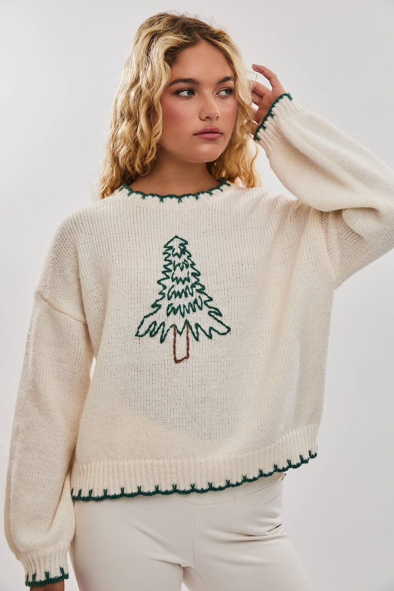 Oversized cream sweater featuring a festive green "Christmas Tree" stitched design, perfect for cozy Long Island boutique fashion.